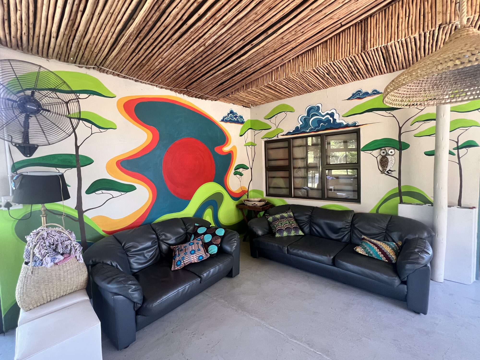 Open-plan lounge with hand-painted bushveld mural
