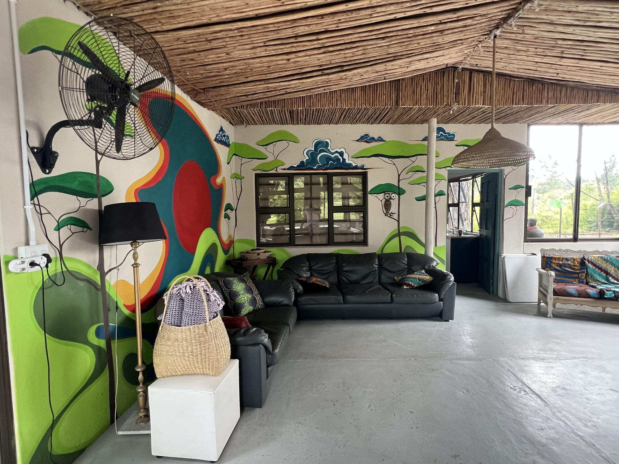Wide view of the central lounge under a thatched ceiling