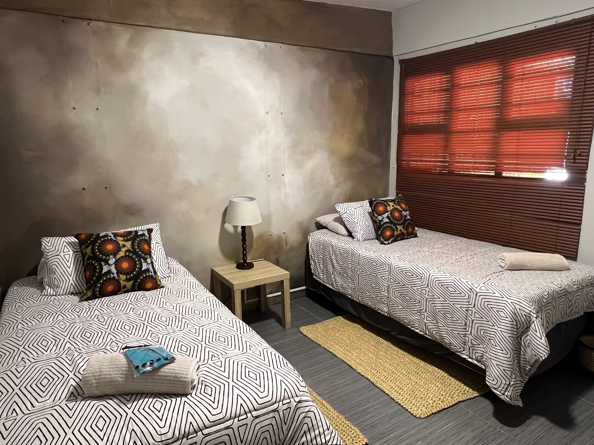 A Skhova Camp bedroom with crisp white linen and bush views